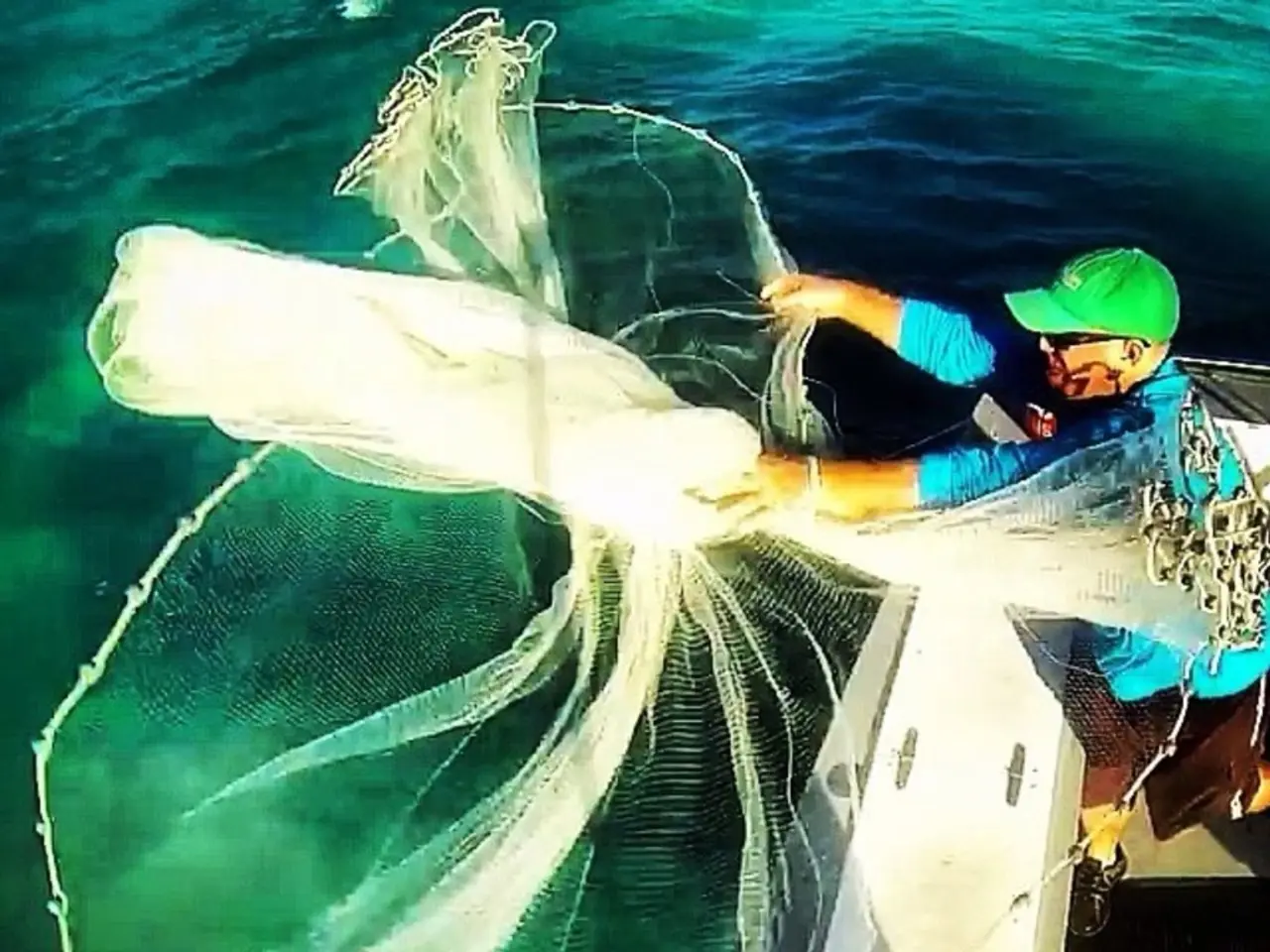 As we can see in the image there is a boat, a man standing over here, net and water.