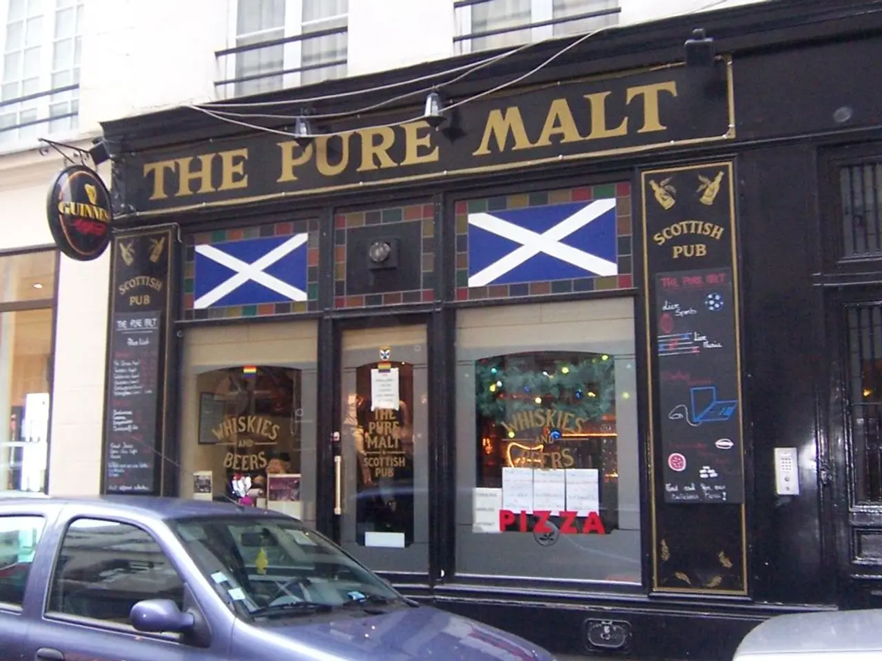 In this picture we can see the shop with glass door. On the there is a white color building with...