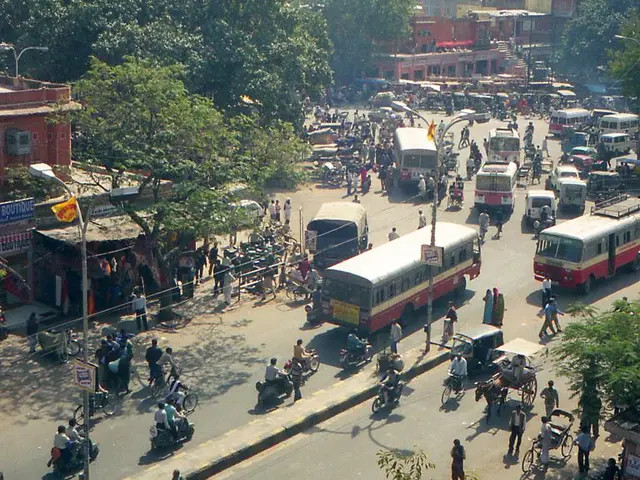 In this picture we can see a few vehicles on the road. There are people, street lights, poles, some...