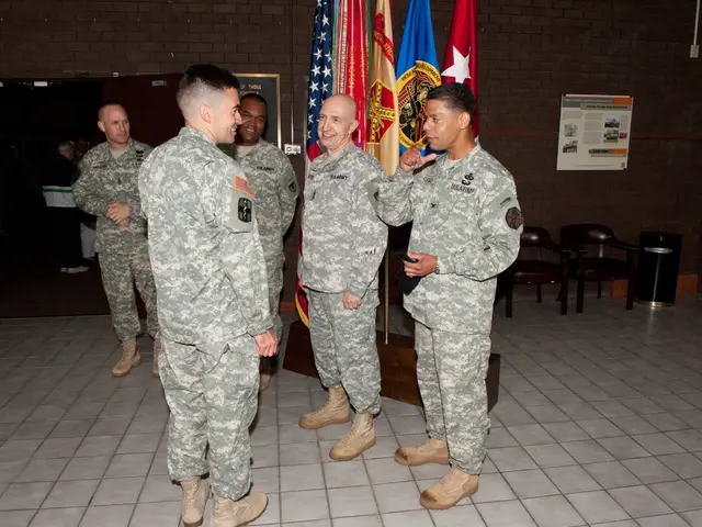 The image is taken in the room in the center of the image there are five men standing and talking....