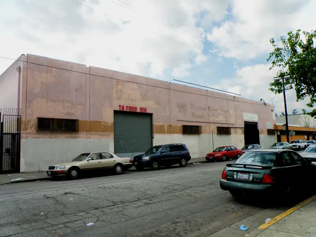 In the center of the image there is a road. There are vehicles on the road. In the background of...