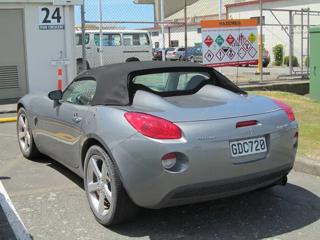 In this picture there is a car in the center of the image and there are other cars in the...